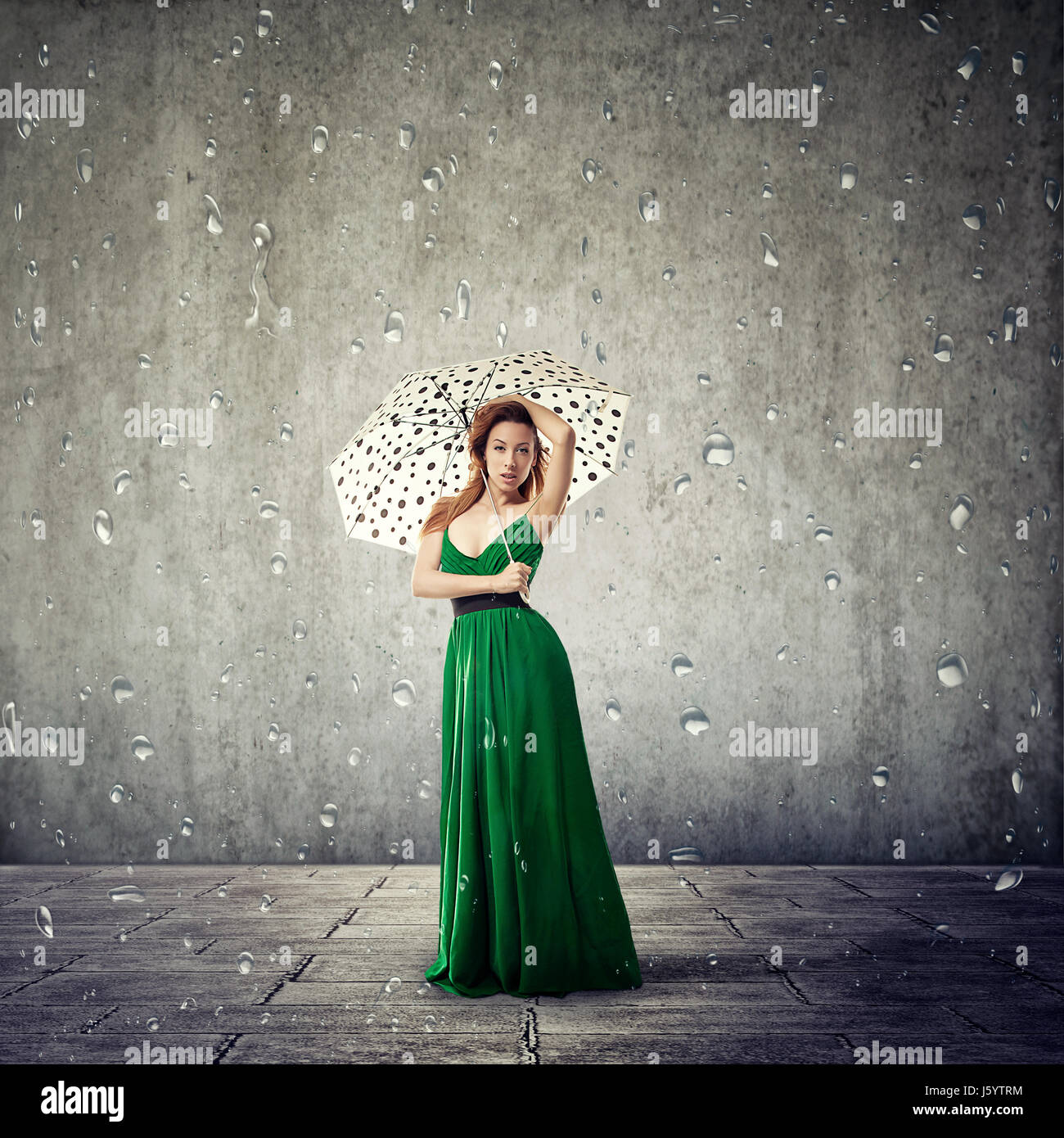 woman with umbrella on gray wall background Stock Photo - Alamy
