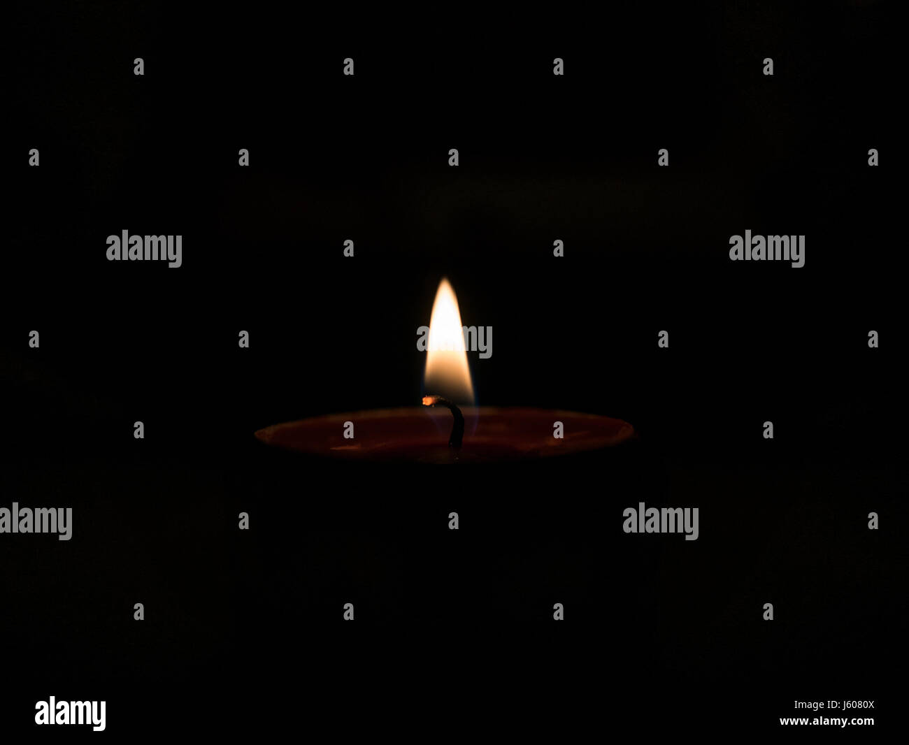 Single small candle burning in the dark Stock Photo Alamy