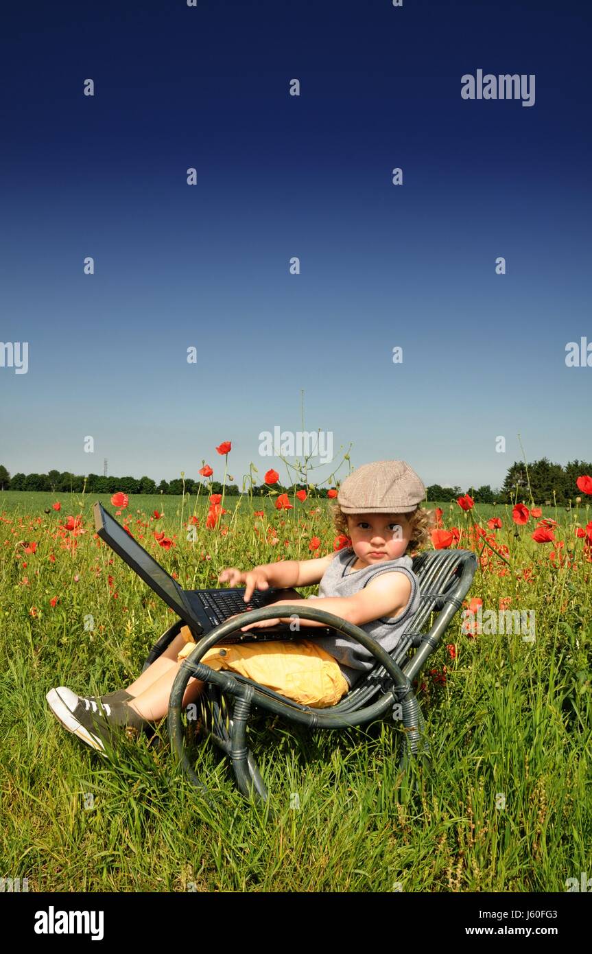 field relaxed meadows contented child children kids blue laptop ...