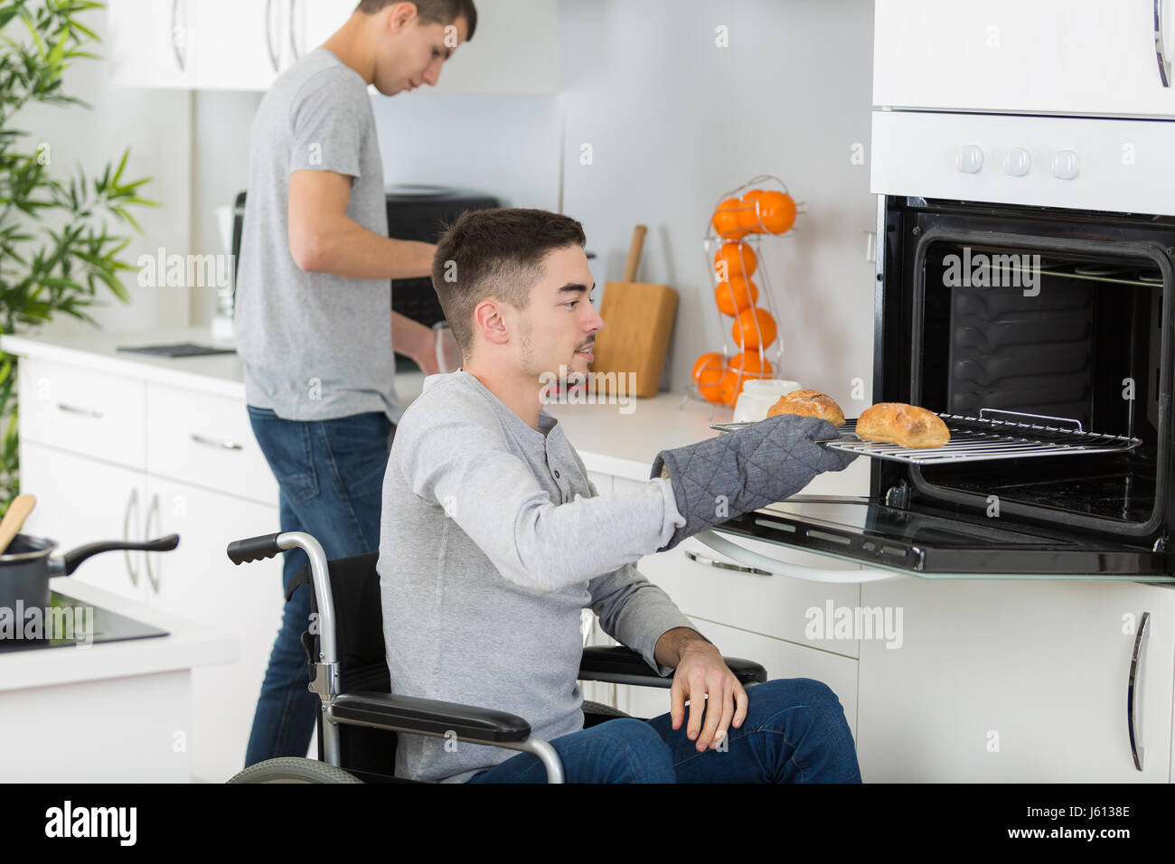 Disabled man taking food from oven Stock Photo Alamy