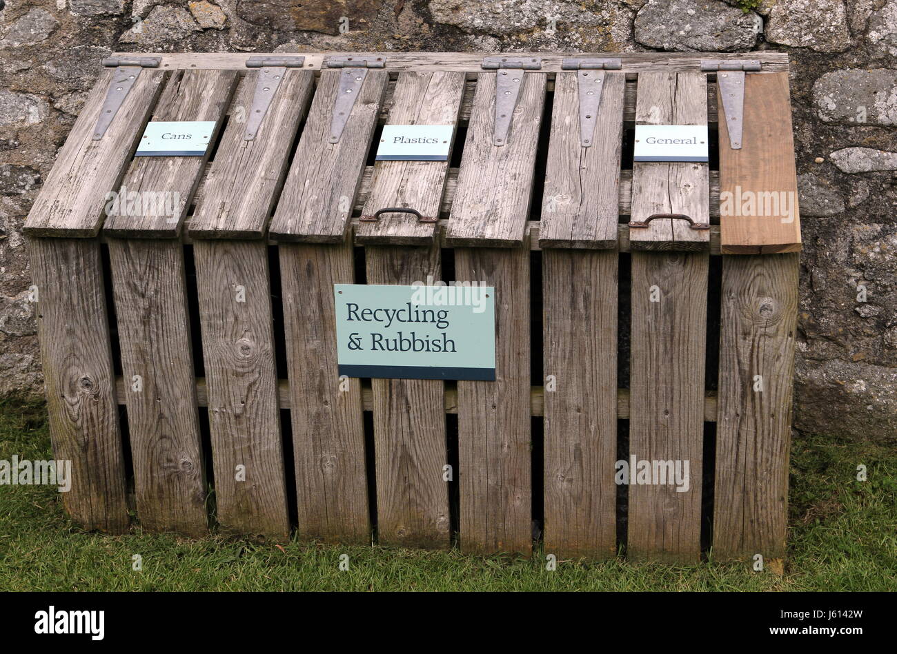 Wooden recycling and rubbish centre with labels for cans, plastics and