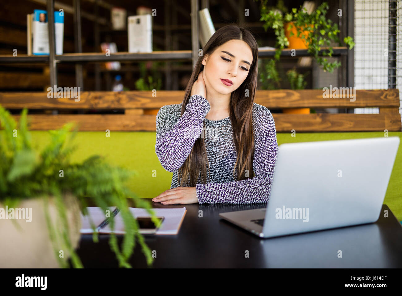 Beautiful woman suffering from neck pain in office Stock Photo