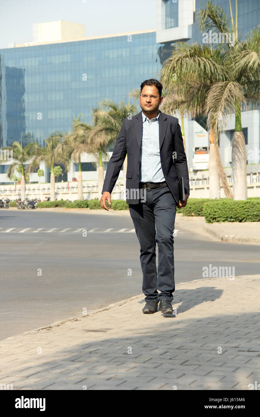 Young Indian corporate man in suit walking to his work Stock Photo