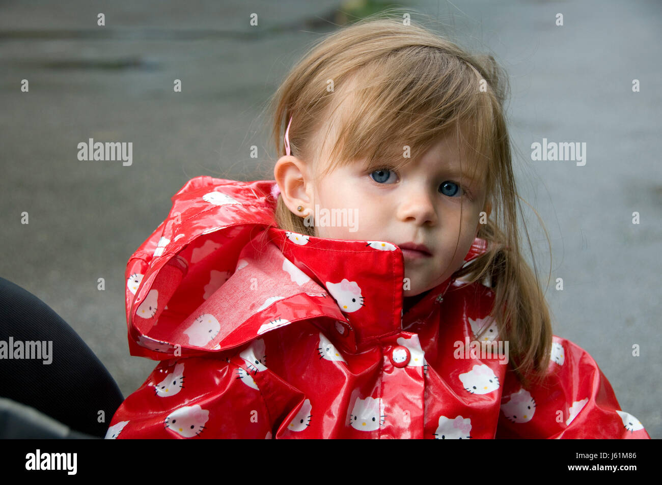 dank young younger child girl girls flower rose plant sad rainy raincoat Stock Photo