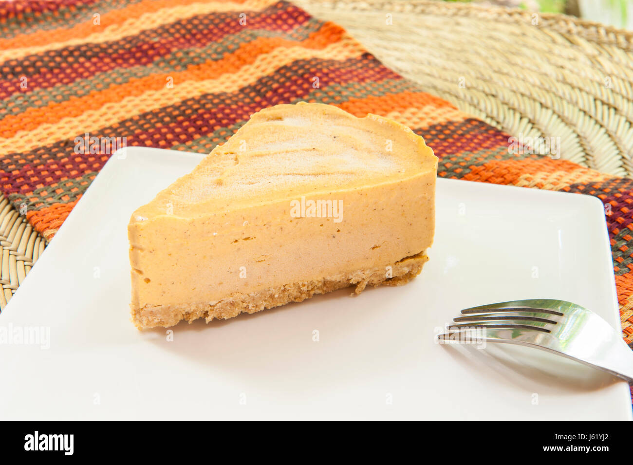 Slice of pumpkin pie ice cream cake on a white plate Stock Photo