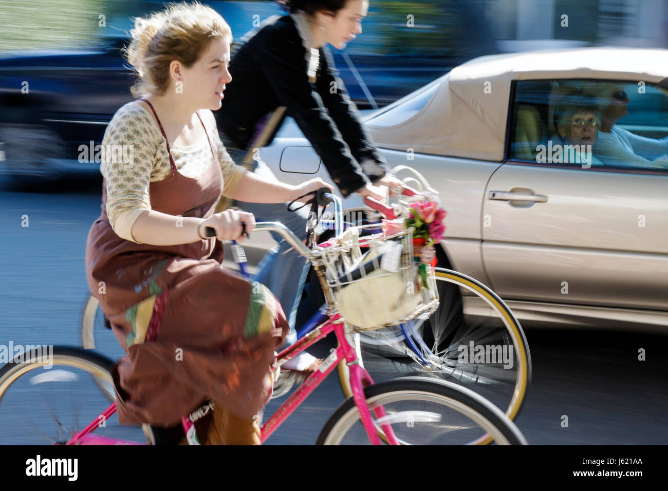 Charleston South Carolina,Broad Street,woman female women adult adults,women,young,old,car,cyclist,bicycle,bicycling,riding,biking,rider,bike,car,bask Stock Photo