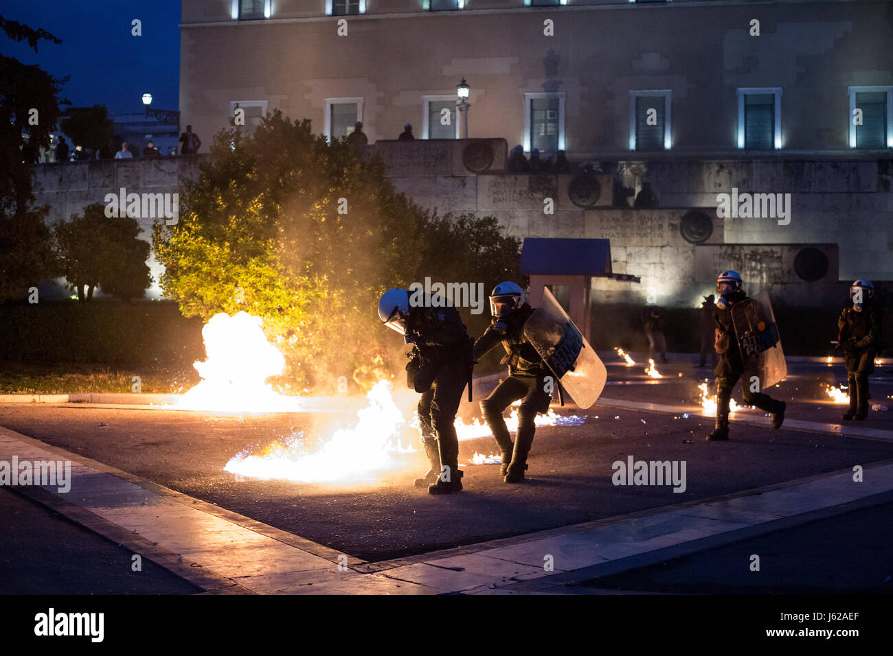 A policeman's uniform catches fire during a demonstration against new austerity measures in front of the Greek Parliament in Athens, Greece, 18 May 2017. During said demonstration police officers were attacked with molotov cocktails. The Greek Parliament is supposed to pass a new austerity package. Labour unions have called extensive strikes against the austerity measures. Photo: Socrates Baltagiannis/dpa Stock Photo