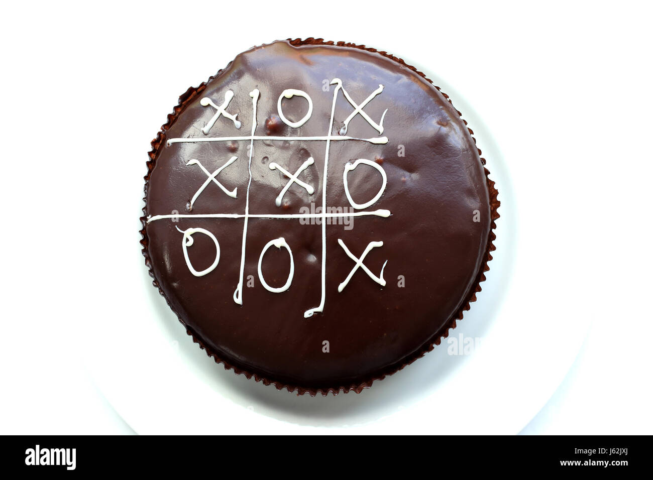 Noughts and crosses on mud cake isolated against white background Stock Photo