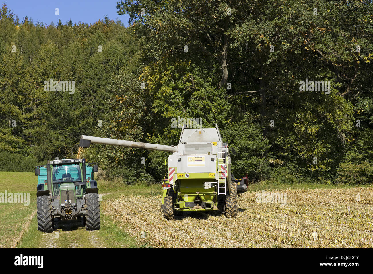 agriculture farming acre corn combine harvester tractor field work harvest Stock Photo