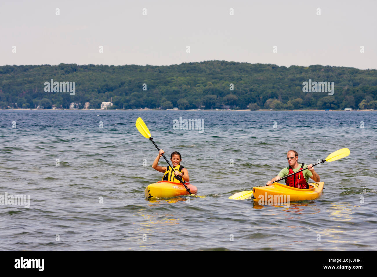 Michigan Traverse City,West Arm Grand Traverse Bay,Clinch Park,kayak,man men male,woman female women,water,sport,recreation,oars,paddle,yellow,orange, Stock Photo