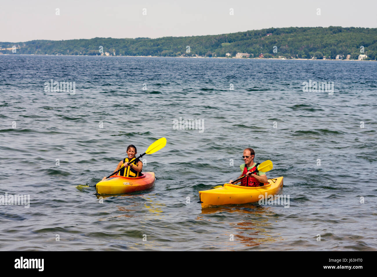 Traverse City Michigan,West Arm Grand Traverse Bay,Clinch Park,kayak,man men male,woman female women,water,sport,recreation,oars,paddle,yellow,orange, Stock Photo