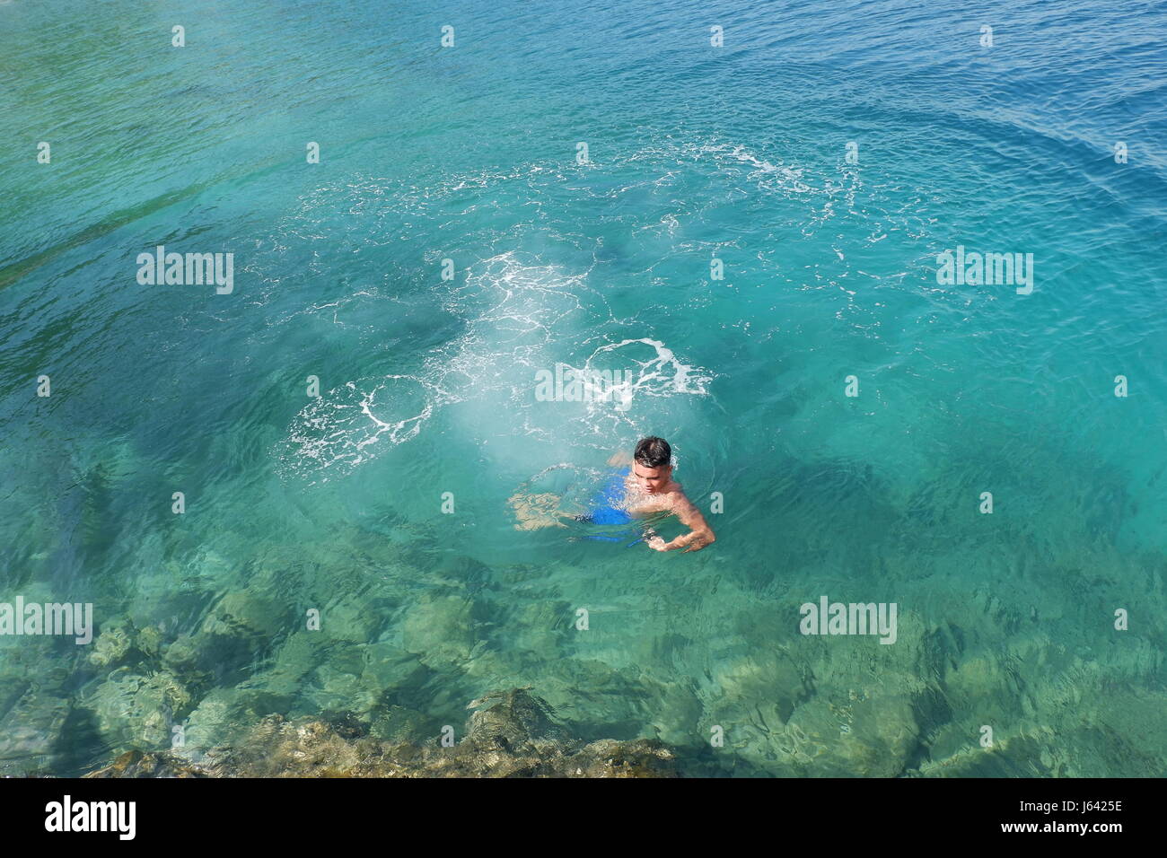 A Boy's Refreshing Dip in the Sea Stock Photo
