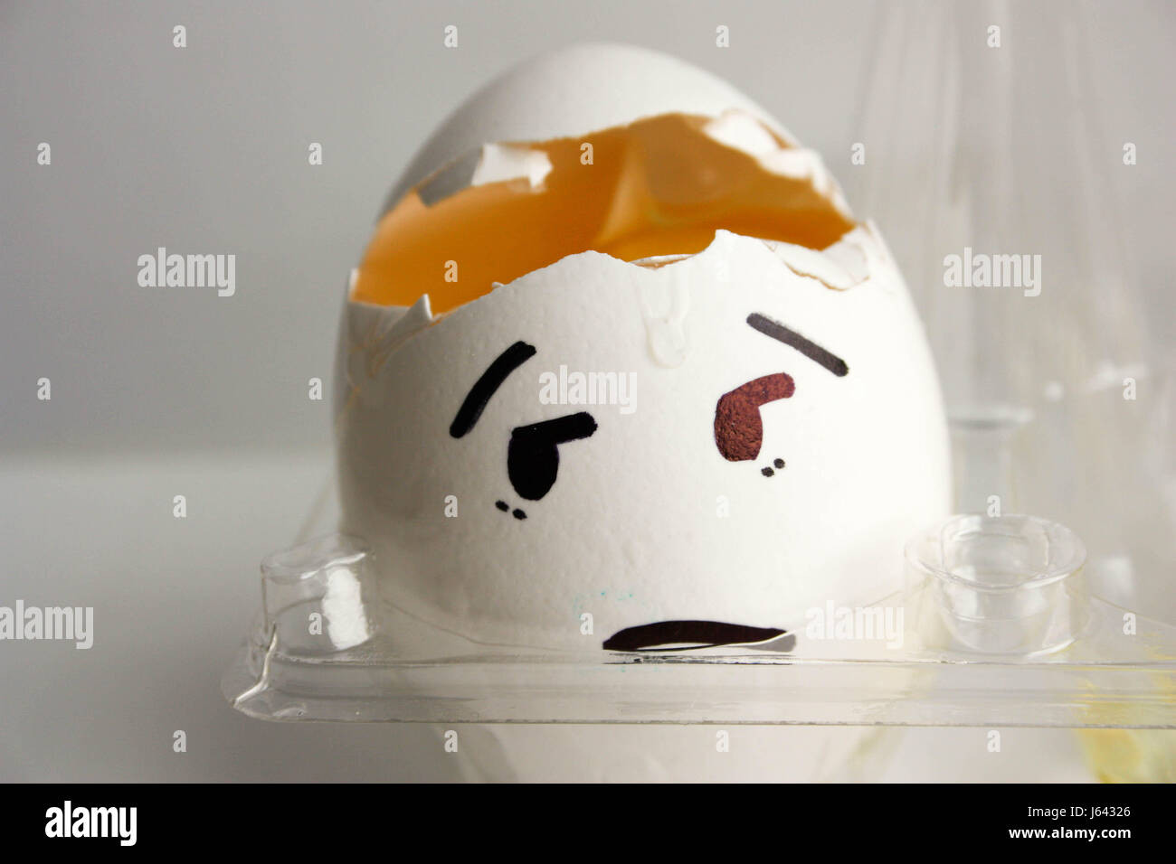 An egg with a face. Concept of headache. His head cracked. Photo for