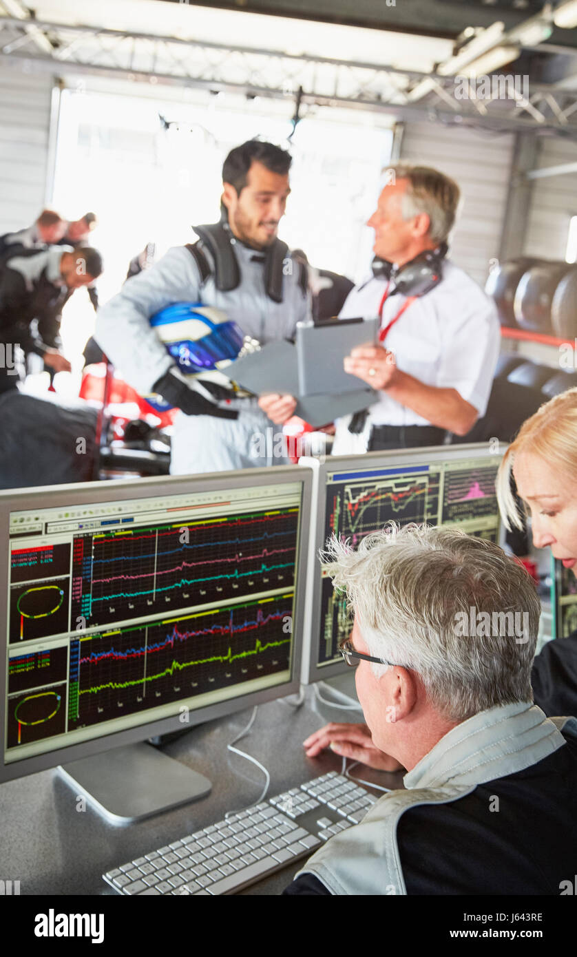 Formula one team reviewing diagnostics in repair garage Stock Photo Alamy