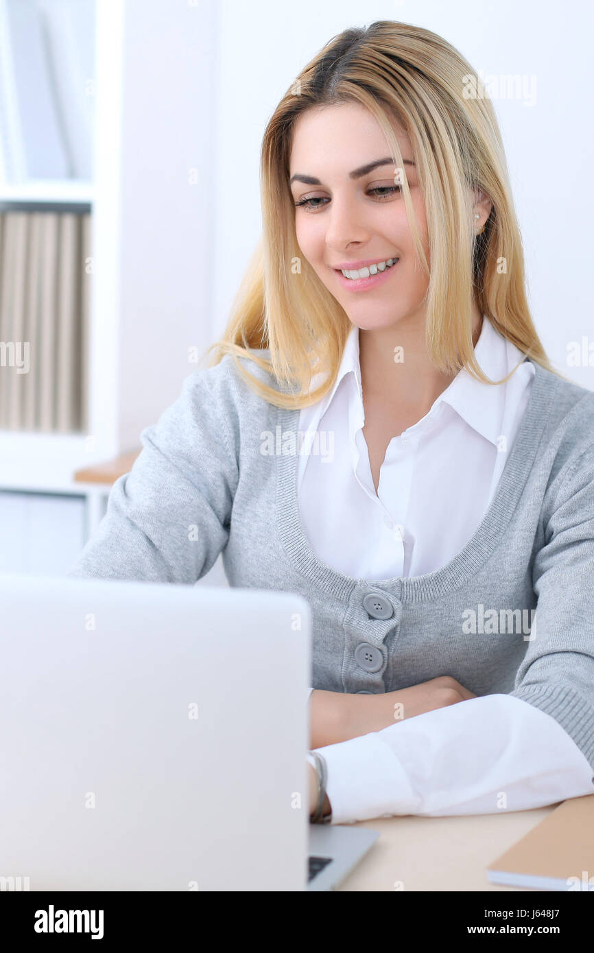 Young business woman or student girl sitting at office workplace with