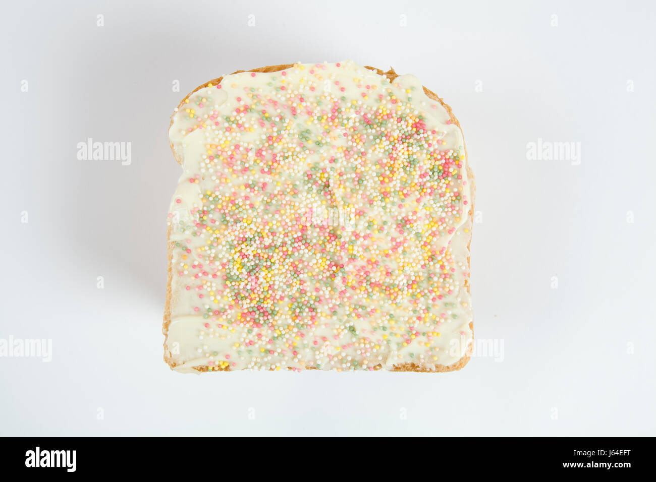 a quirky icing birthday bread covered with sprinkles on white background Stock Photo
