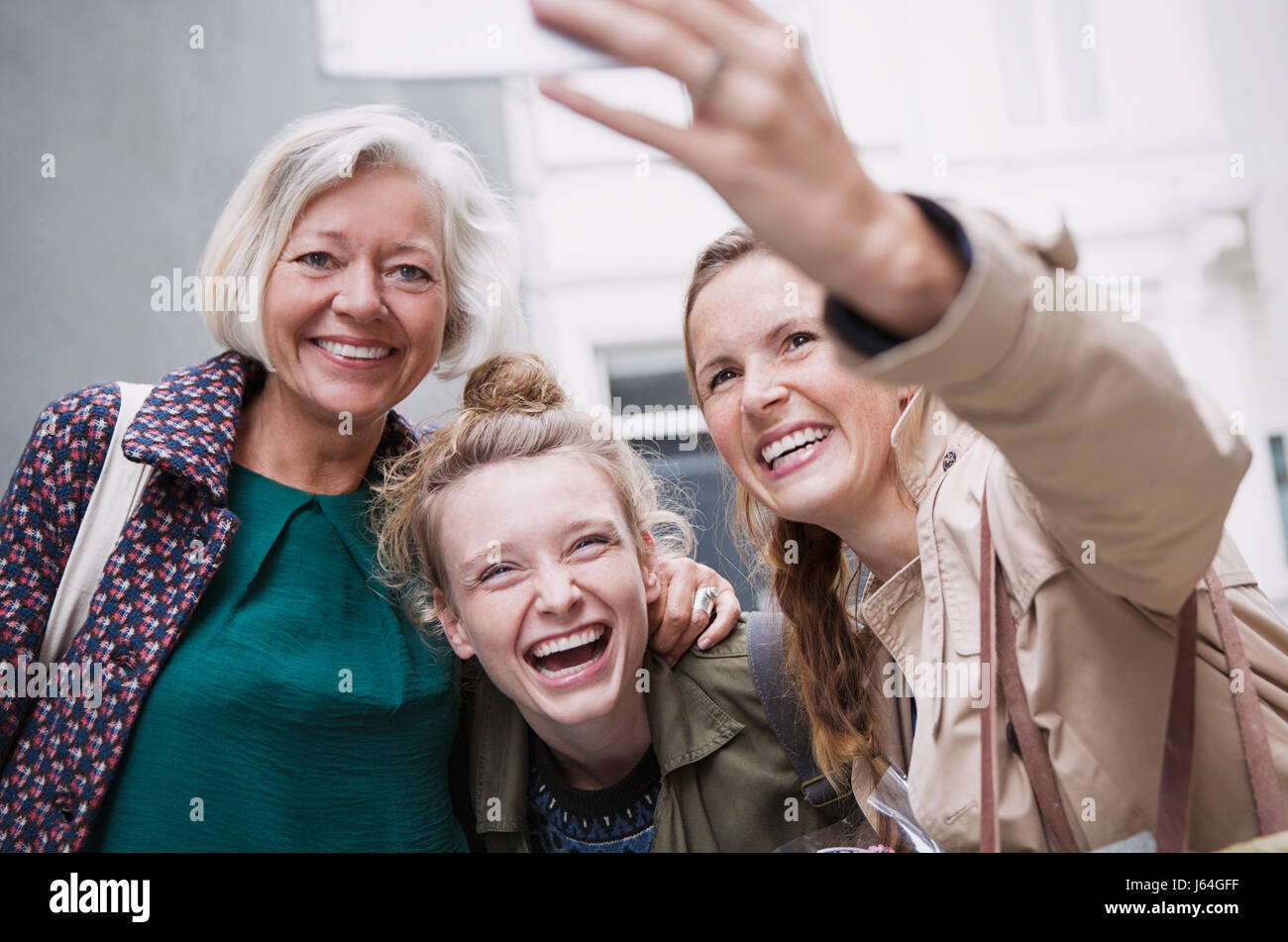 Laughing mother and daughters taking selfie Stock Photo