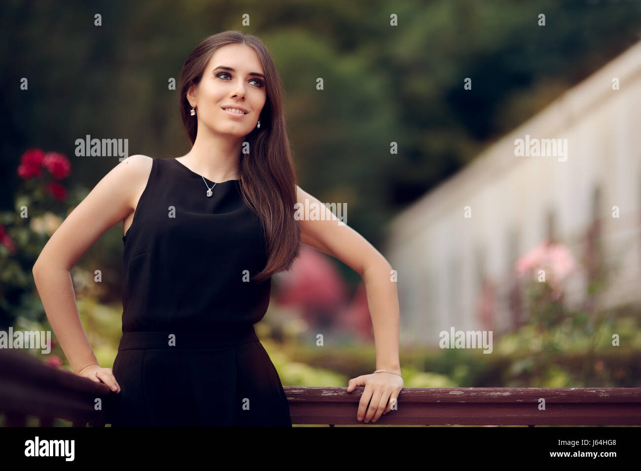 Elegant Woman Wearing Black Dress Standing in a Patio Stock Photo