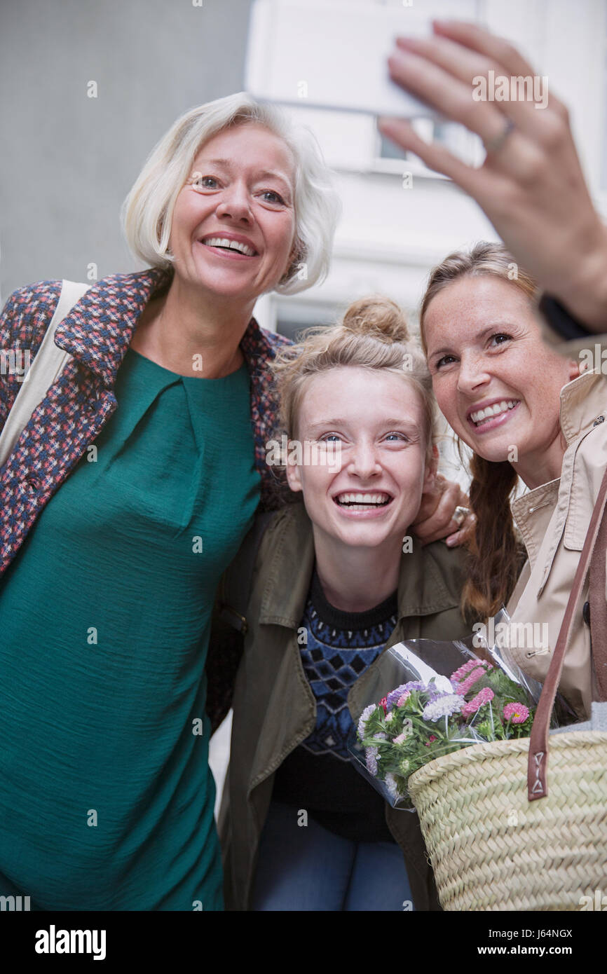 Smiling mother and daughters taking selfie with camera phone Stock Photo