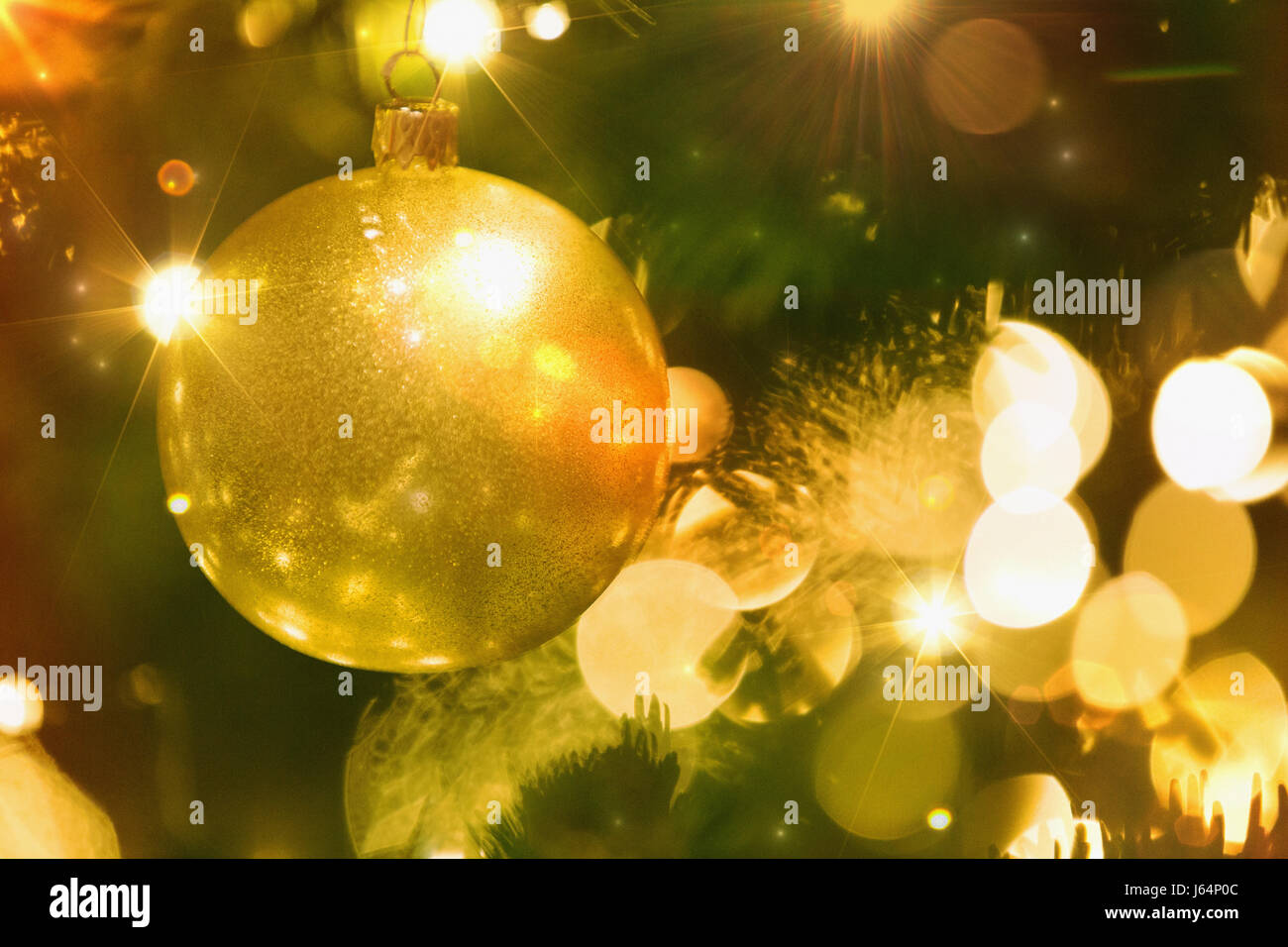 Close up golden ornament and string lights on Christmas tree Stock