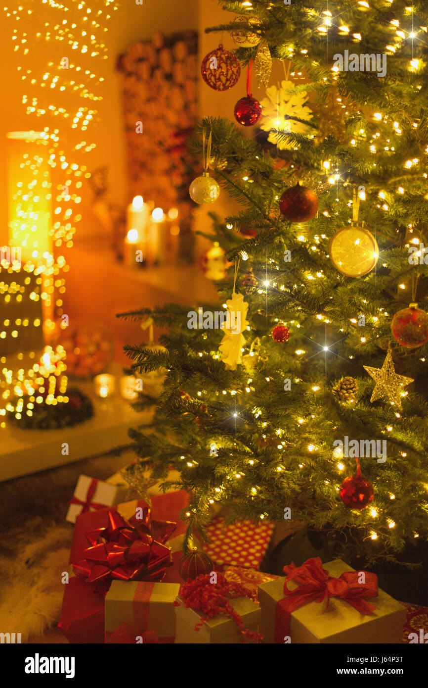 Gifts under illuminated Christmas tree Stock Photo