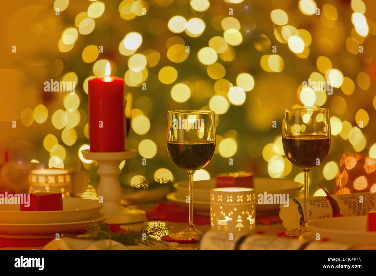 Red wine and candles on ambient Christmas dinner table Stock Photo