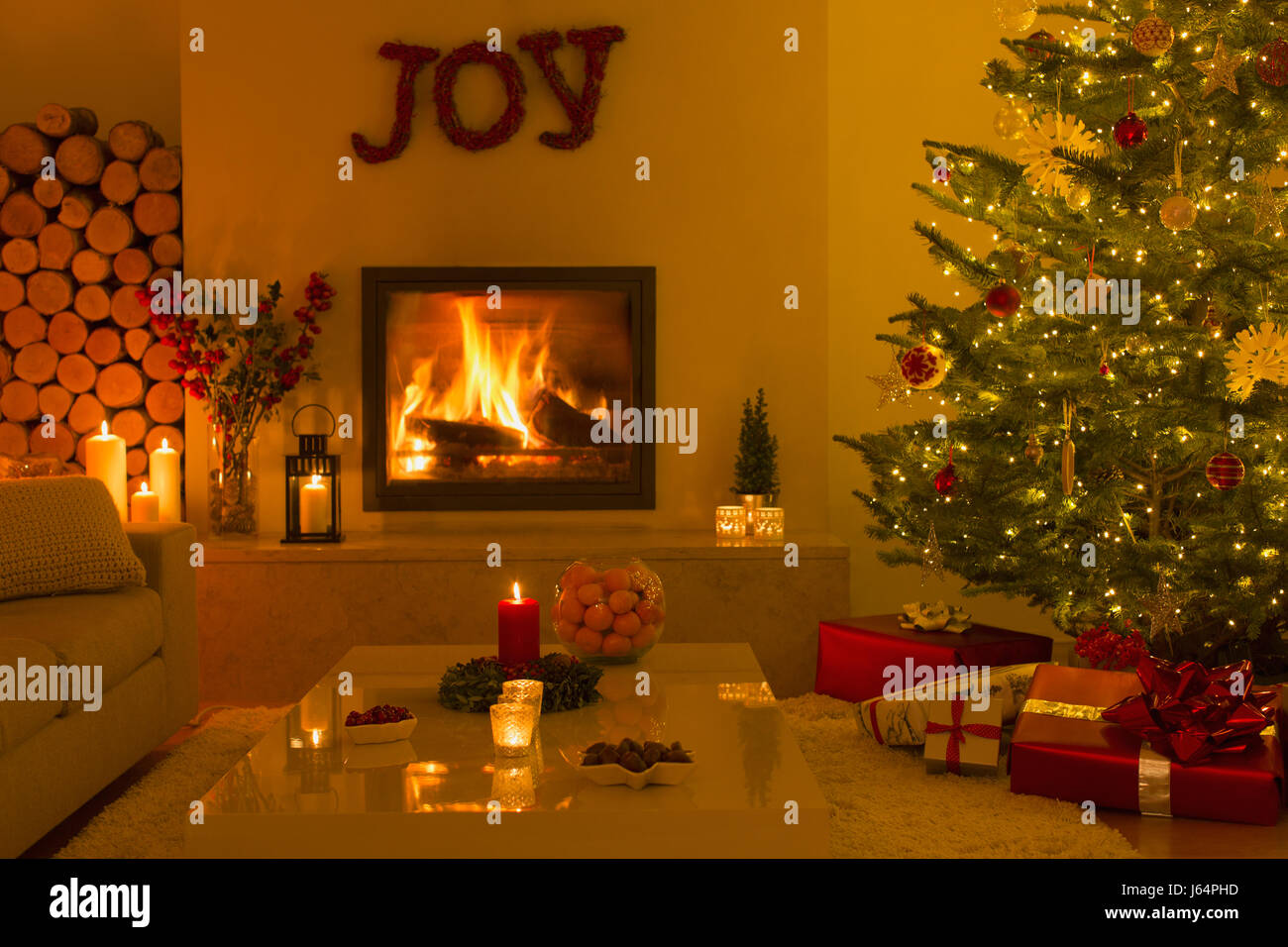 Ambient fireplace and candles in living room with Christmas tree Stock Photo