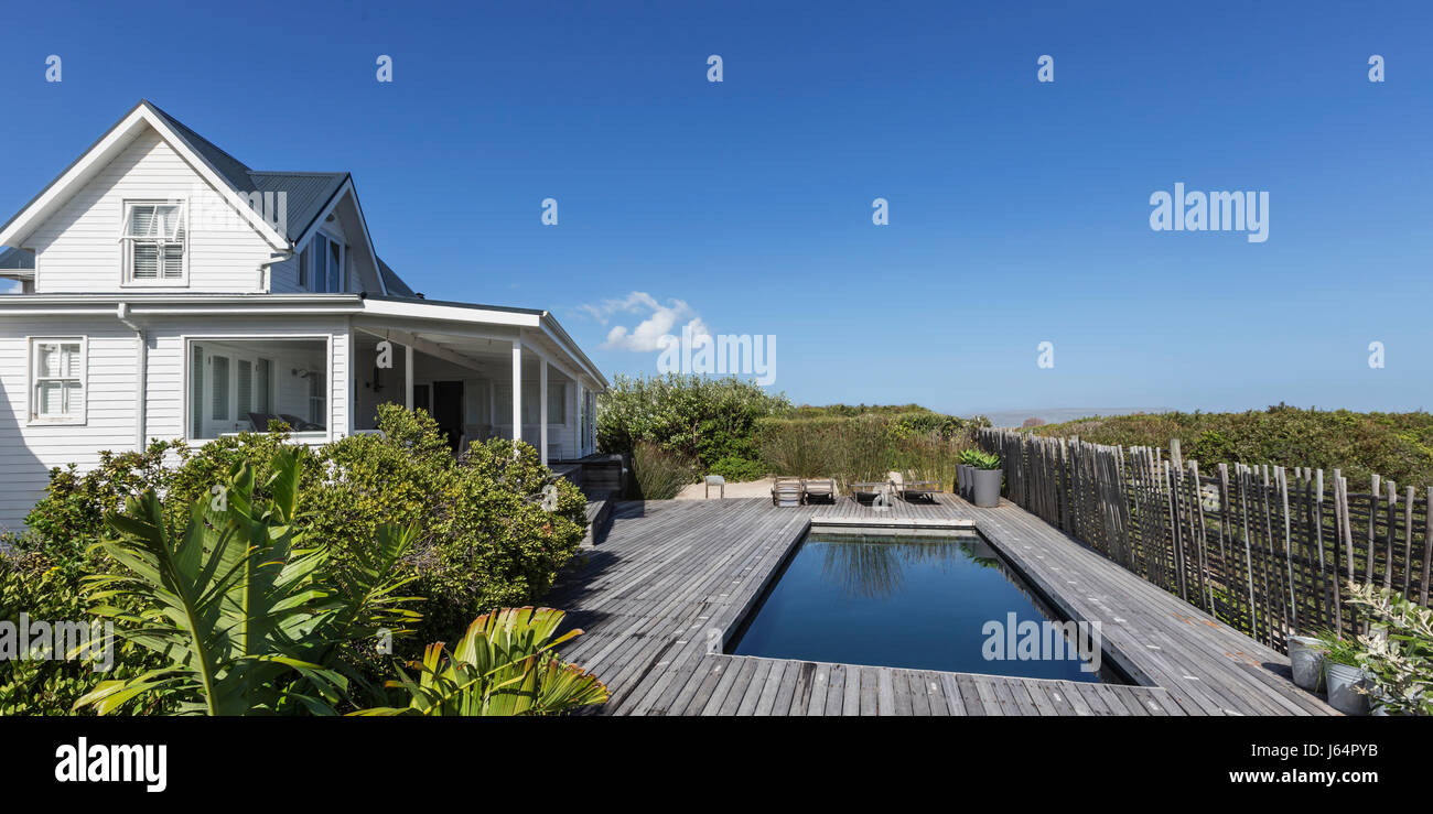White home showcase exterior and swimming pool under sunny blue sky Stock Photo