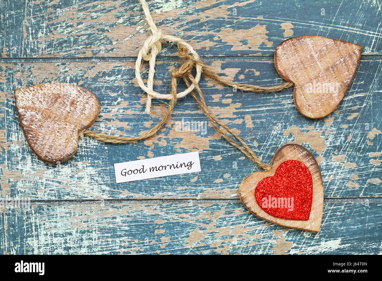 Good morning card with three wooden hearts on rustic wooden surface Stock Photo