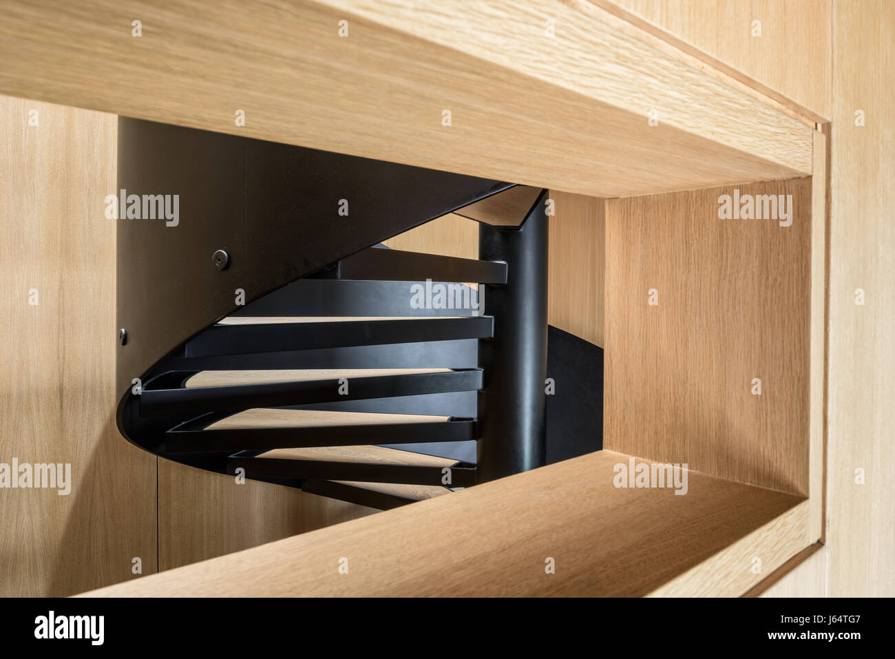 White oak veneer and black steel spiral staircase. Stock Photo