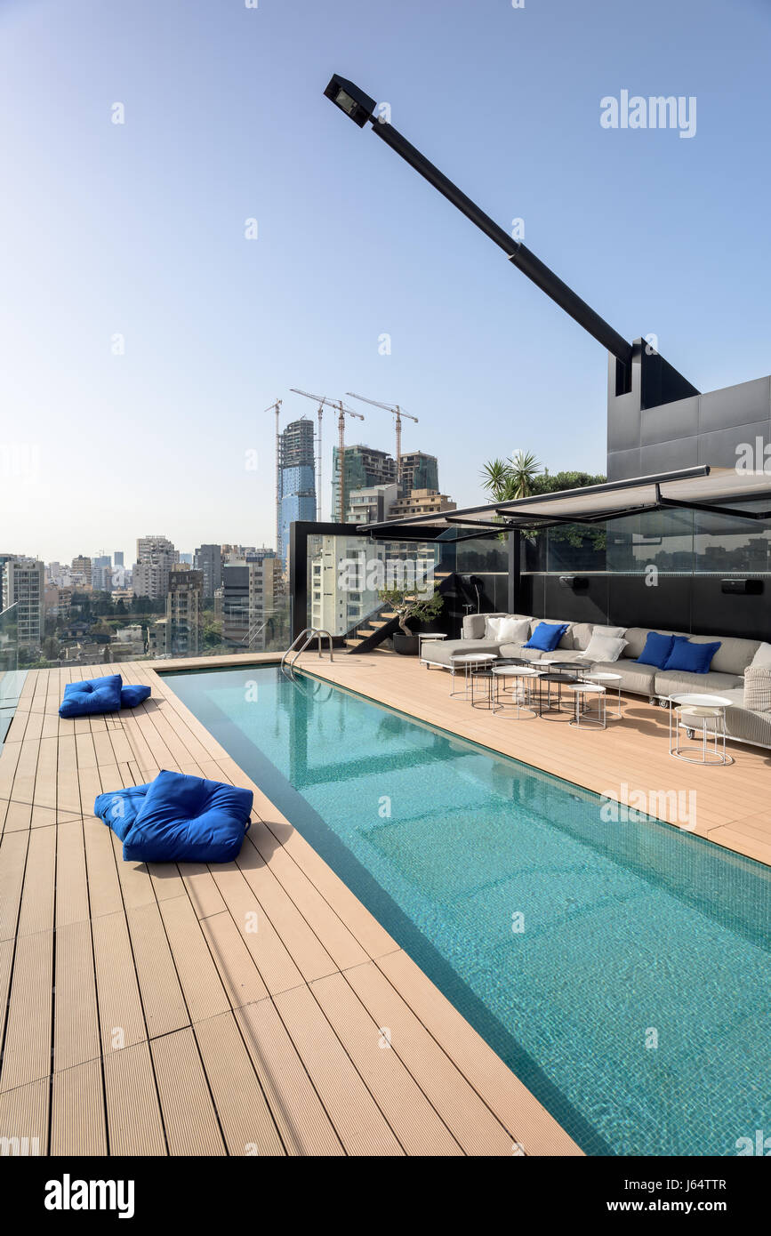 Roof top swimming pool with pair of Khoury-designed black pivotting antennae lights. Stock Photo