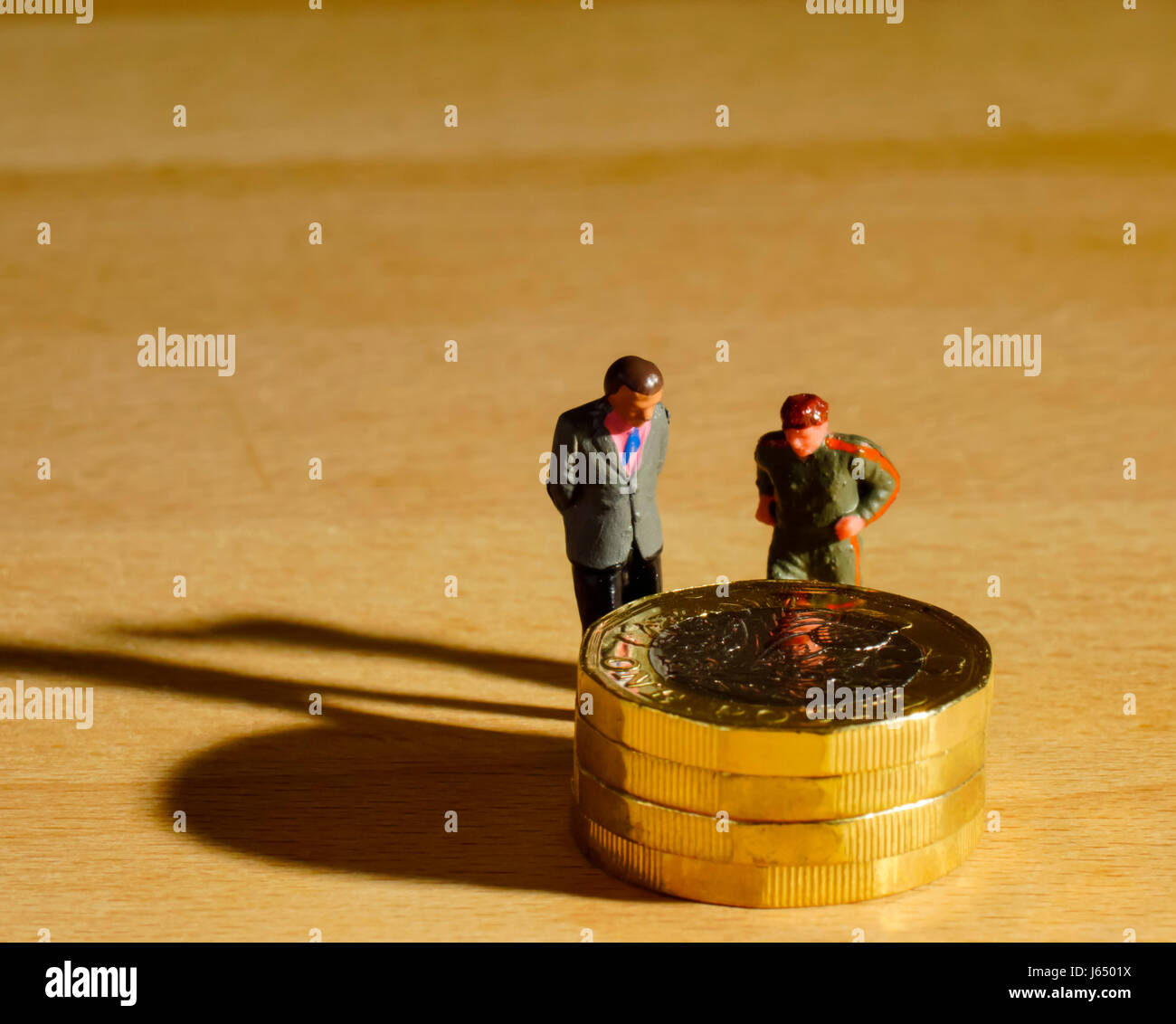 Financial concept UK £1 coin and small people Stock Photo