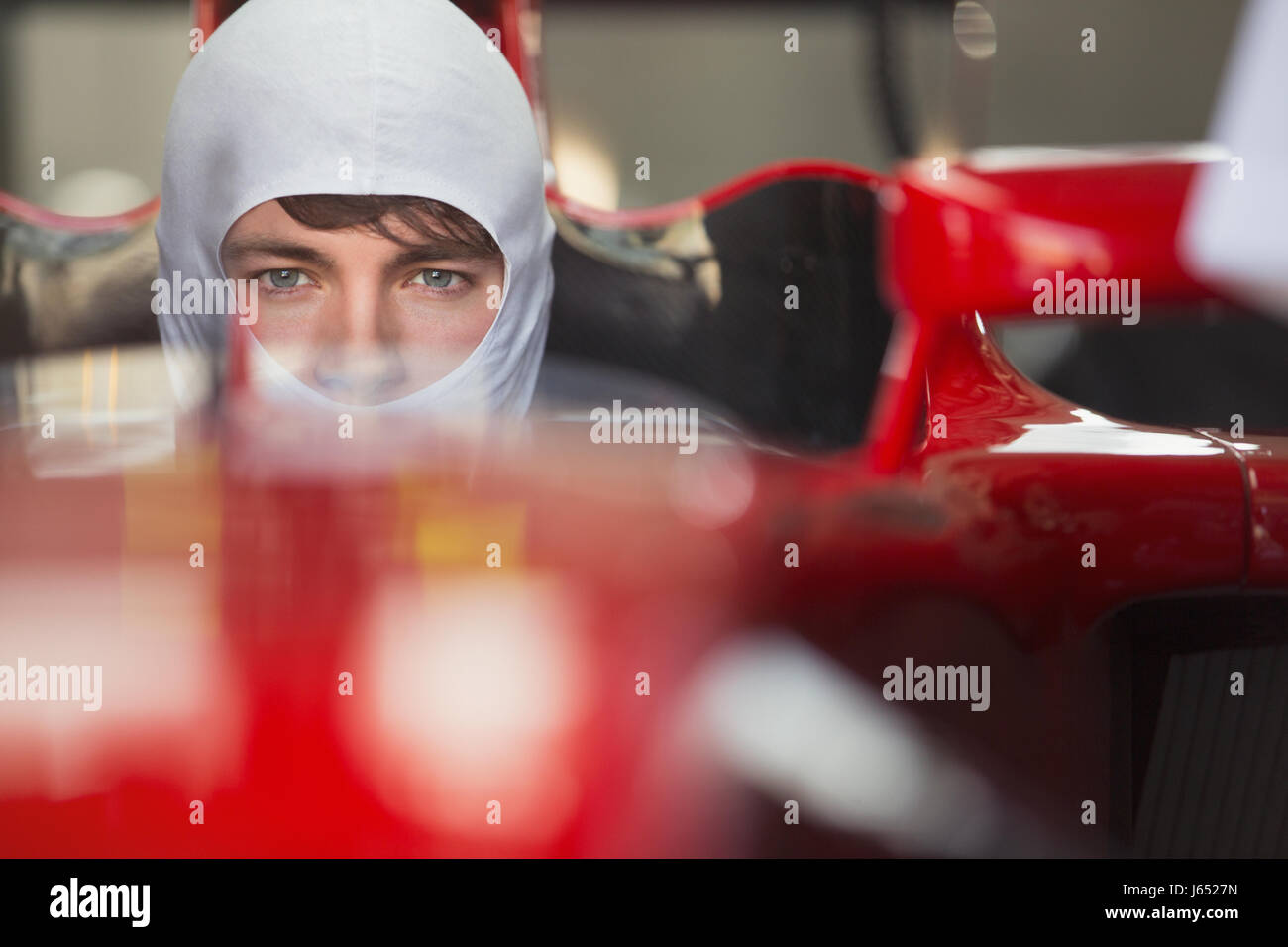 Close up portrait serious formula one race car driver wearing protective mask Stock Photo
