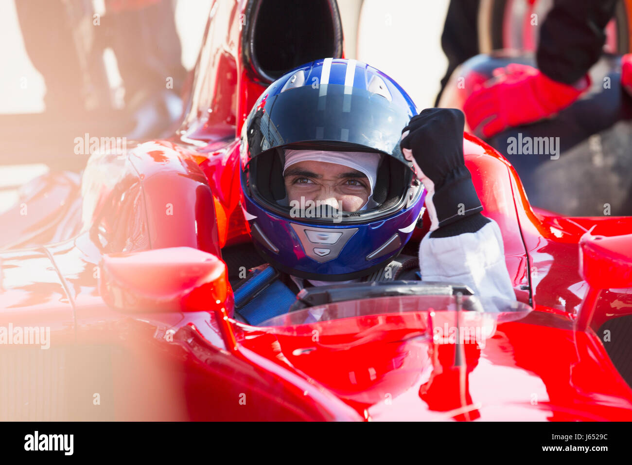 Formula one race car driver in helmet gesturing, celebrating victory Stock Photo