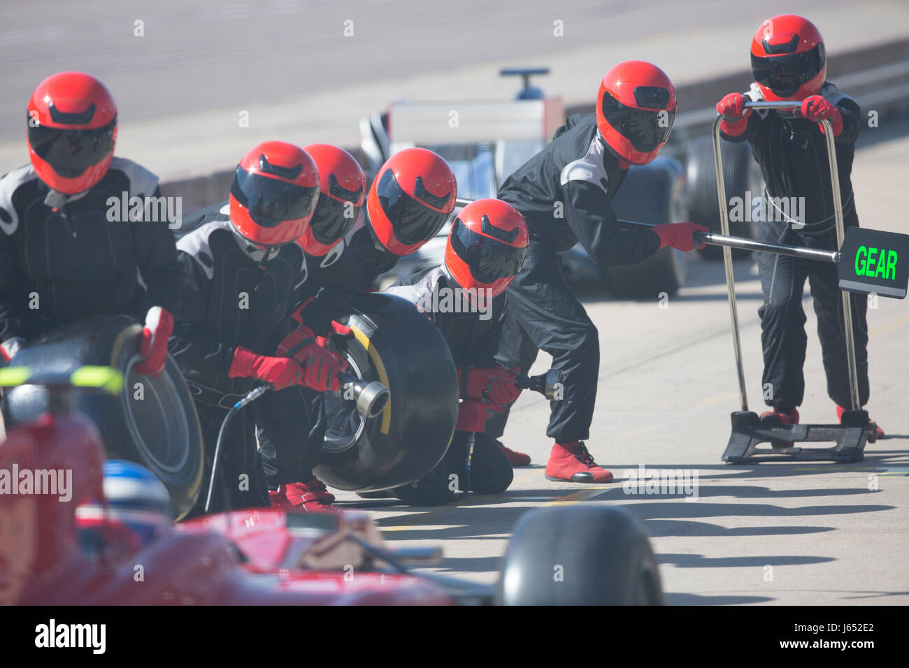 Pit crew with tires ready for nearing formula one race car in pit lane Stock Photo Alamy