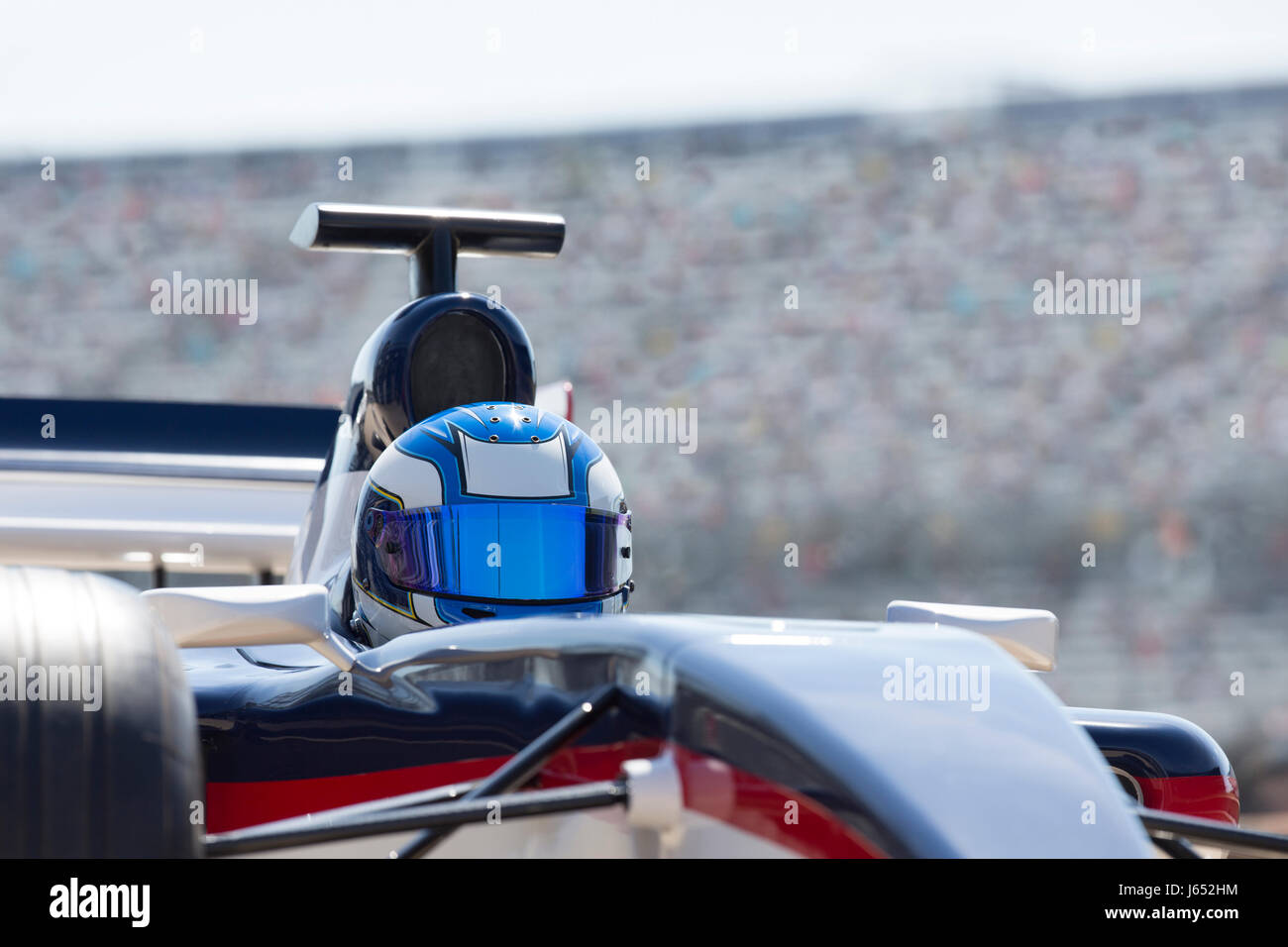 Formula one race car driver wearing helmet on sports track Stock Photo