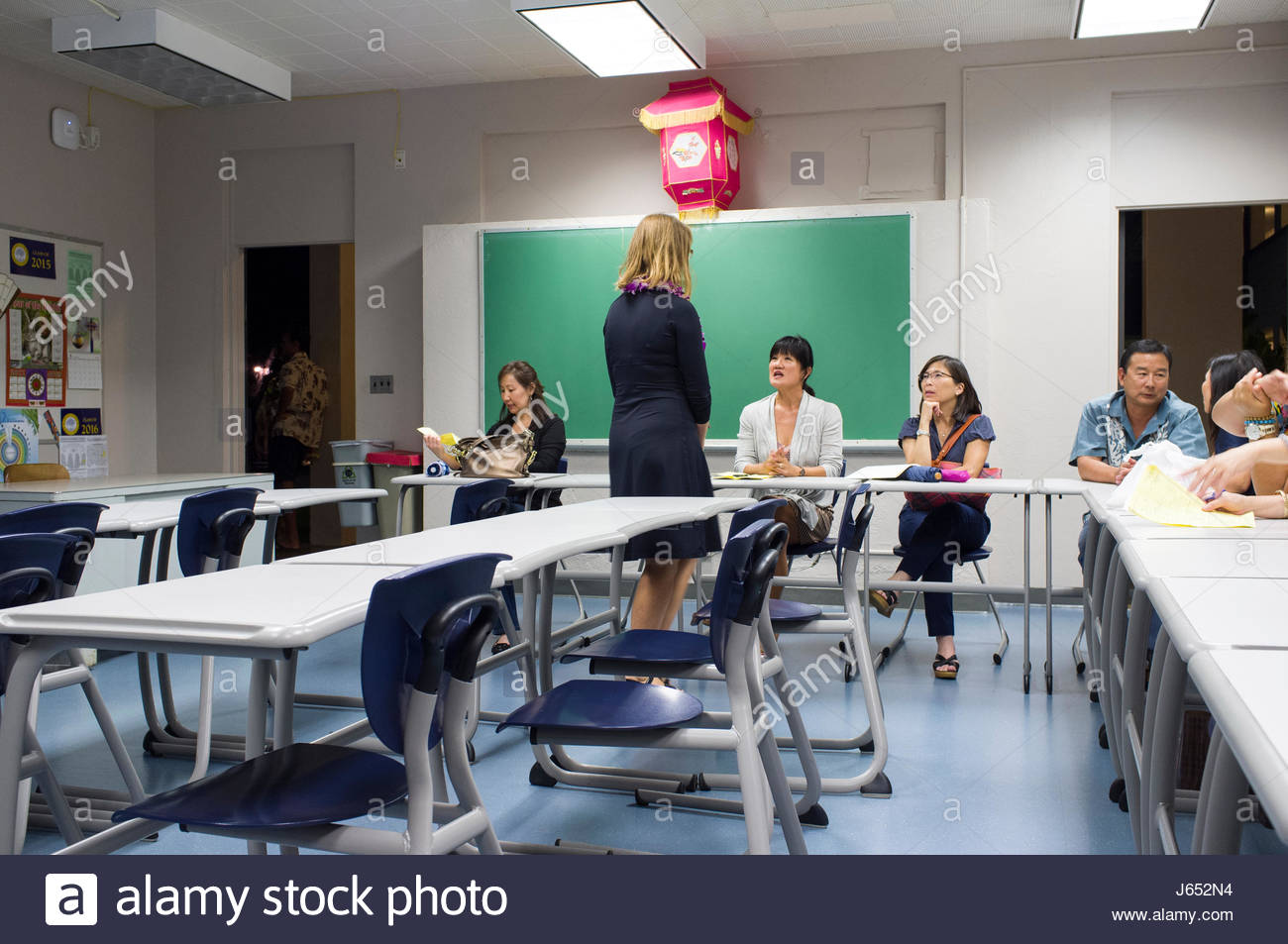 Female Spanish Teacher Talking With Parents During Open