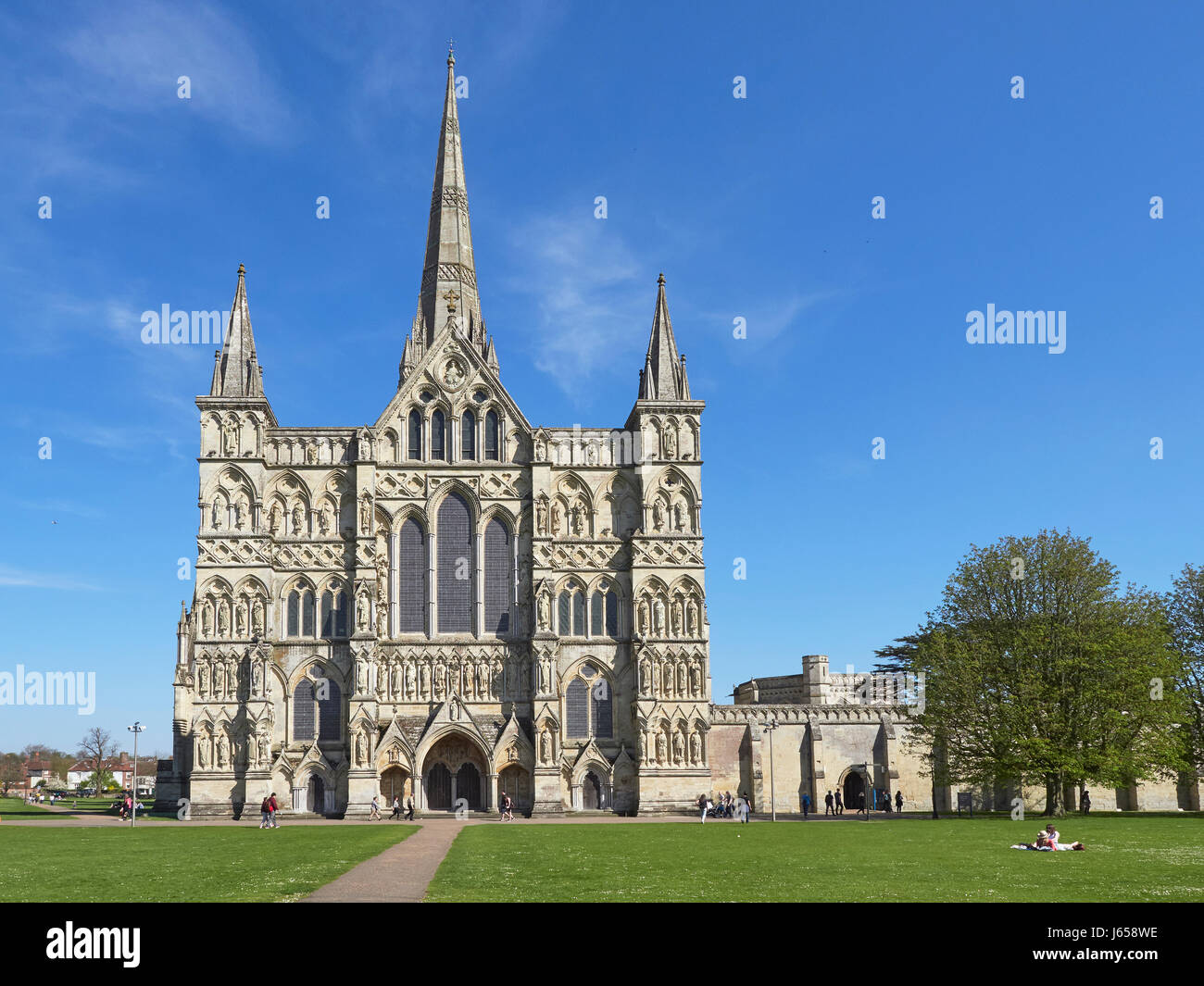 Salisbury Cathedral west front and close with people relaxing in the sun Stock Photo