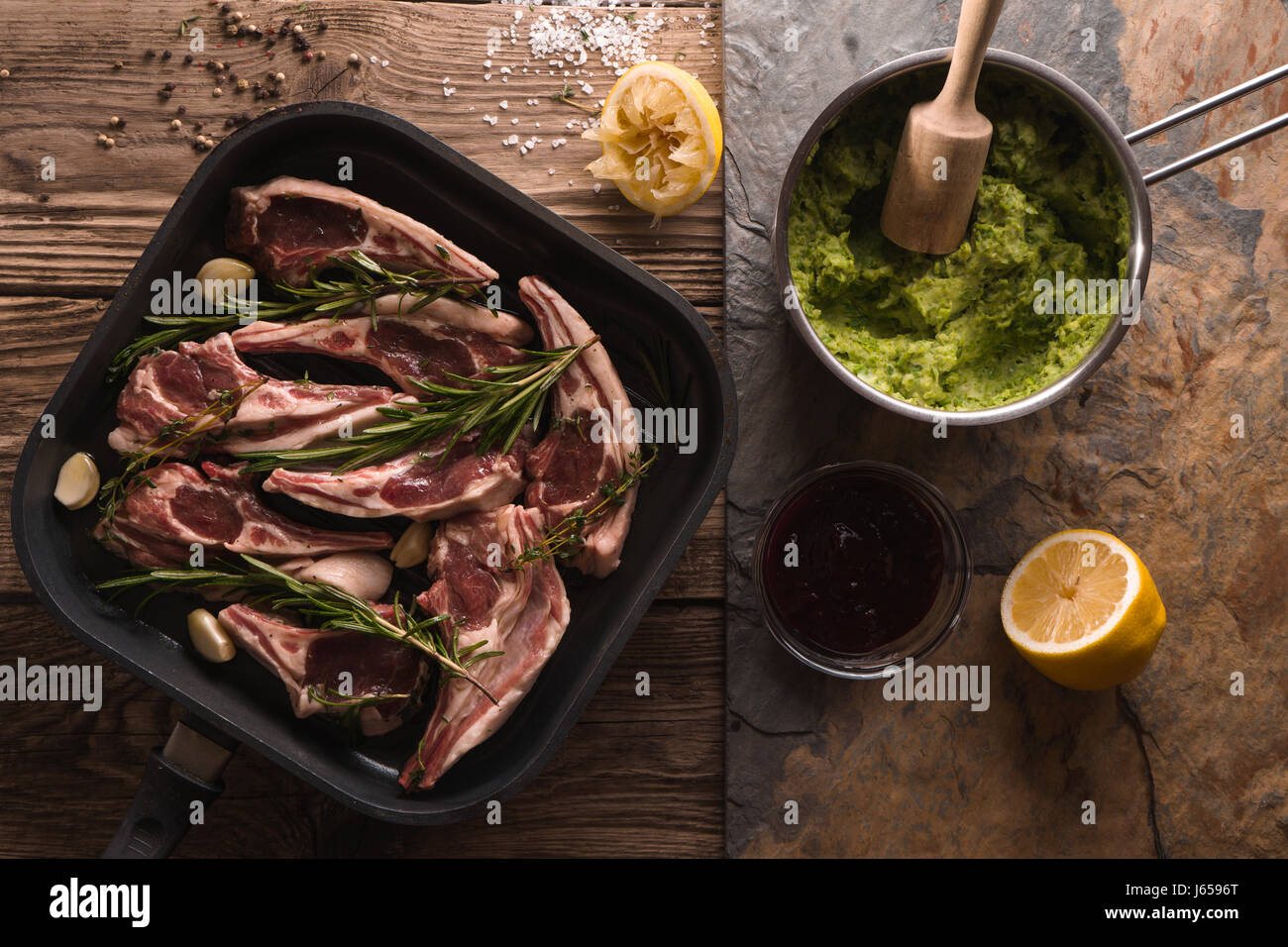 Ribs of lamb in saucepan and mashed potatoes and peas in a ladle Stock Photo