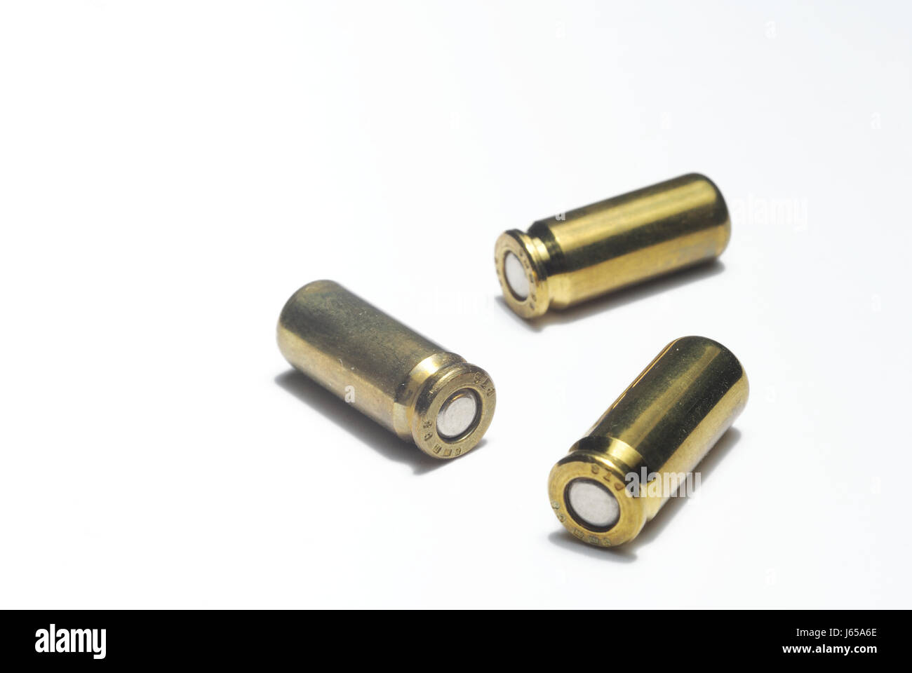 three ammunition cartridge fire arm metal brass husk arm weapon bowl schieen Stock Photo
