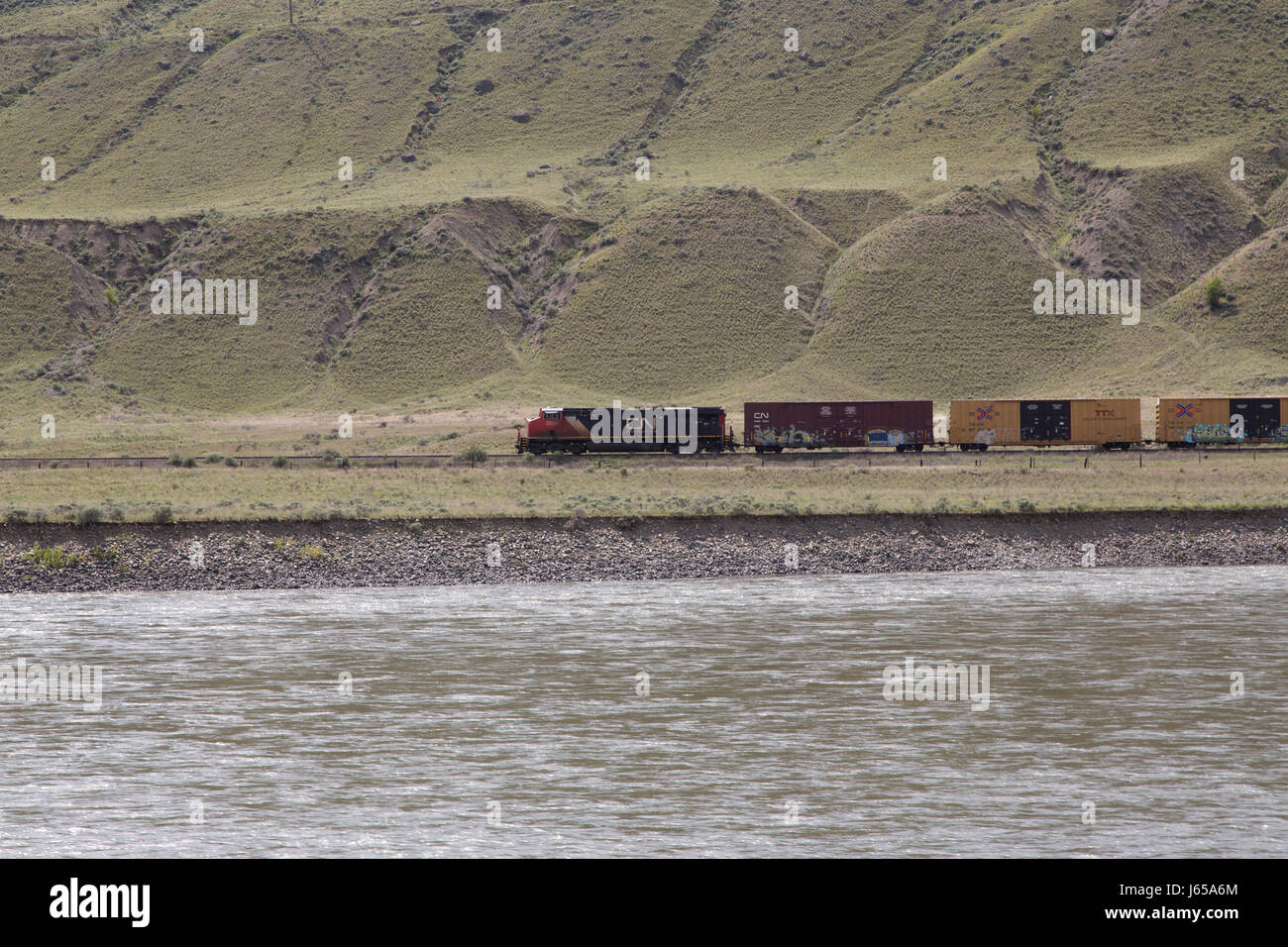 A freight train runs in western Canada. The train can be up to two