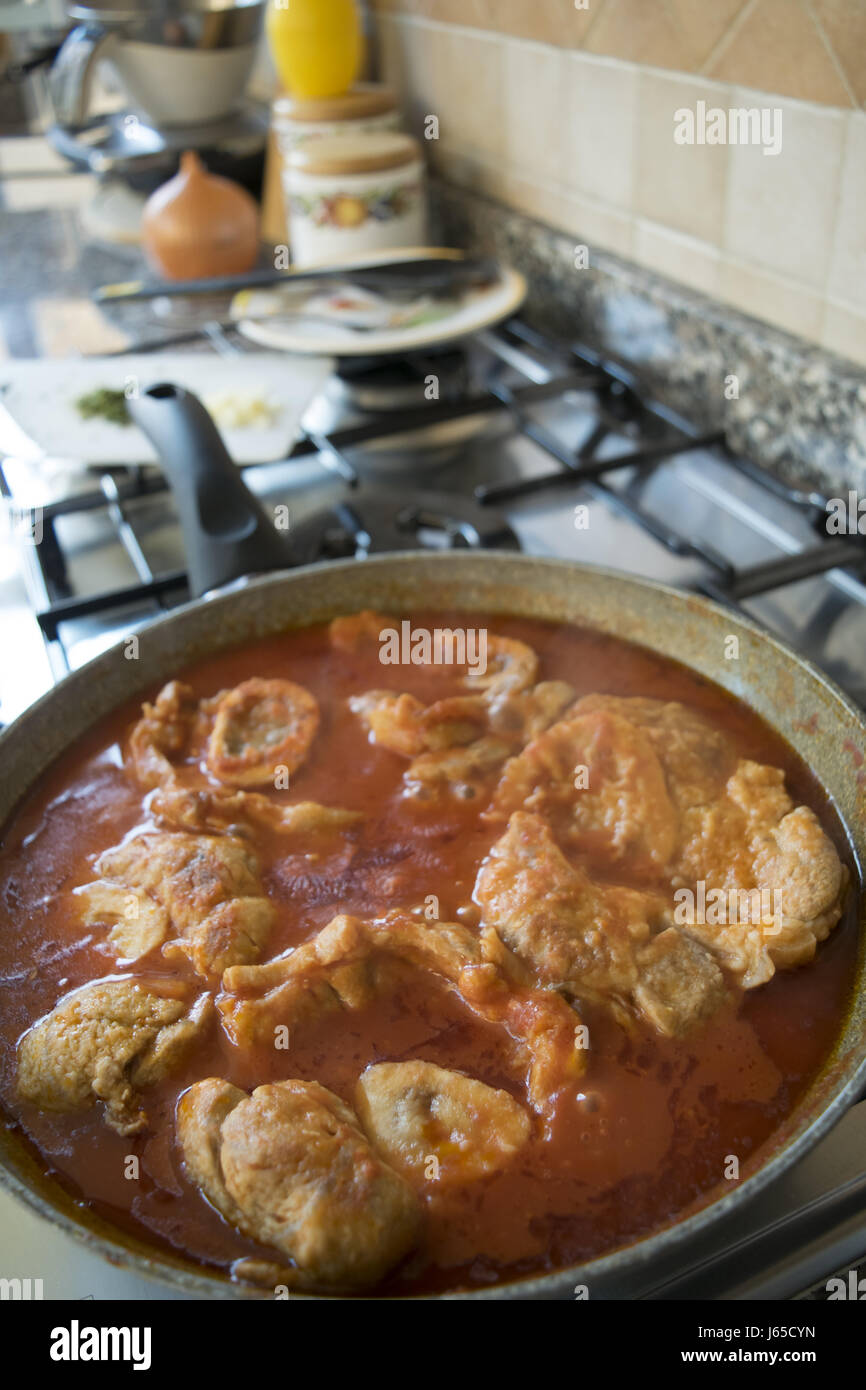 preparing ossobuco in pan with tomato sauce Stock Photo