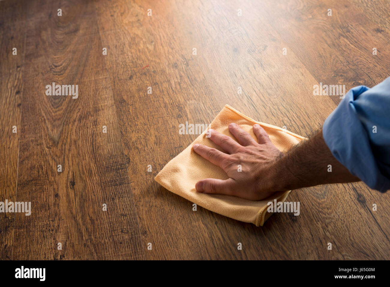 Male Hand Cleaning And Rubbing An Hardwood Floor With A Microfiber