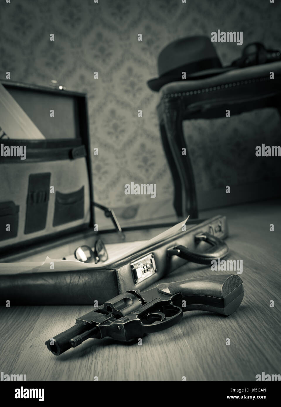 Detective open briefcase with vintage gun on the floor and borsalino hat on  background Stock Photo - Alamy