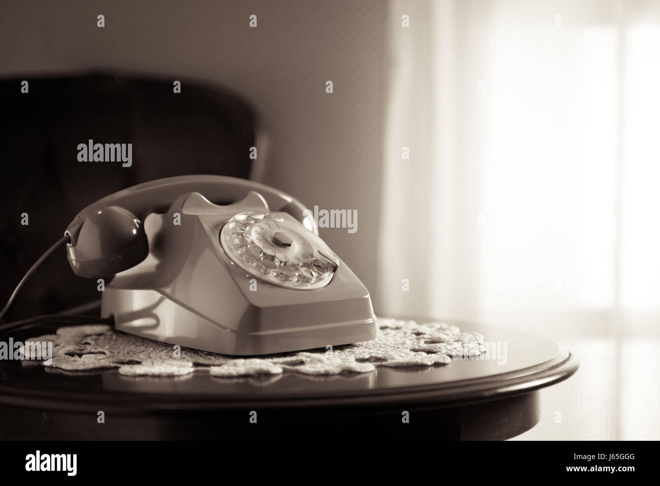 Vintage telephone on doily and wooden table in the living room Stock ...