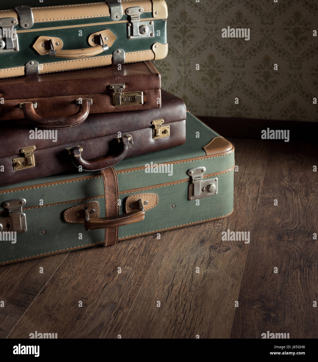 Pile of leather vintage suitcases, retro wallpaper on background Stock