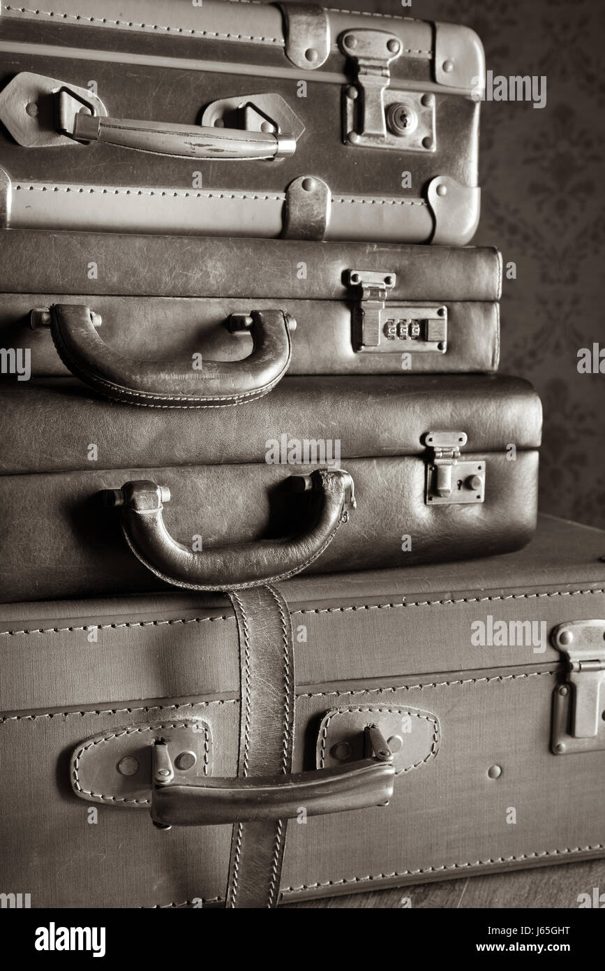 Pile of leather vintage suitcases, retro wallpaper on background Stock