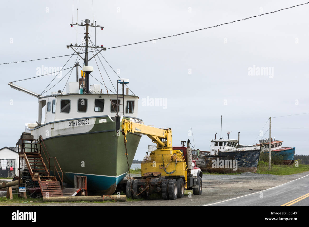 Crane by fishing trawler at harbor, Marie Joseph, Nova Scotia, Canada