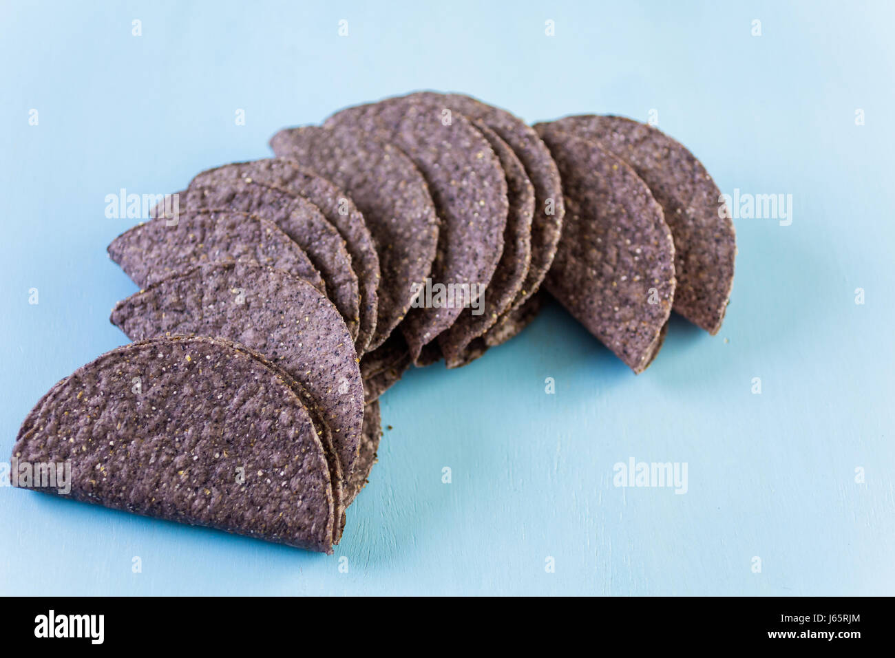 Blue corn taco shells on a blue background Stock Photo - Alamy