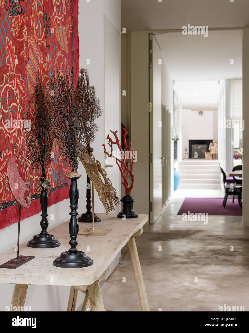 Artwork displayed with red wall covering in atelier hallway, Brussels Stock Photo